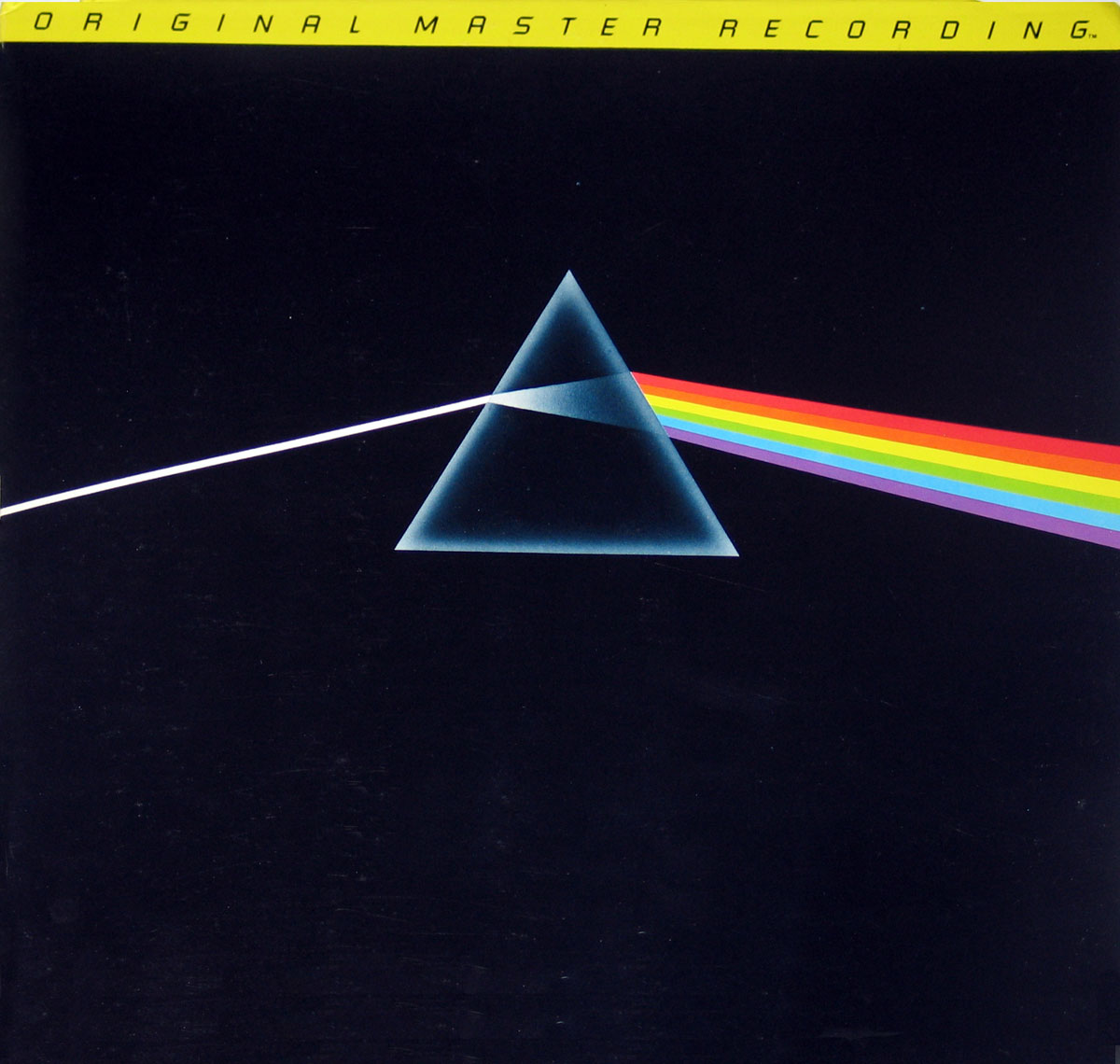 ‘Album cover of Pink Floyd’s The Dark Side of the Moon Mobile Fidelity Sound Lab edition, featuring a black background with a white light beam entering a prism, splitting into a rainbow spectrum. A yellow banner at the top reads “ORIGINAL MASTER RECORDING.”’